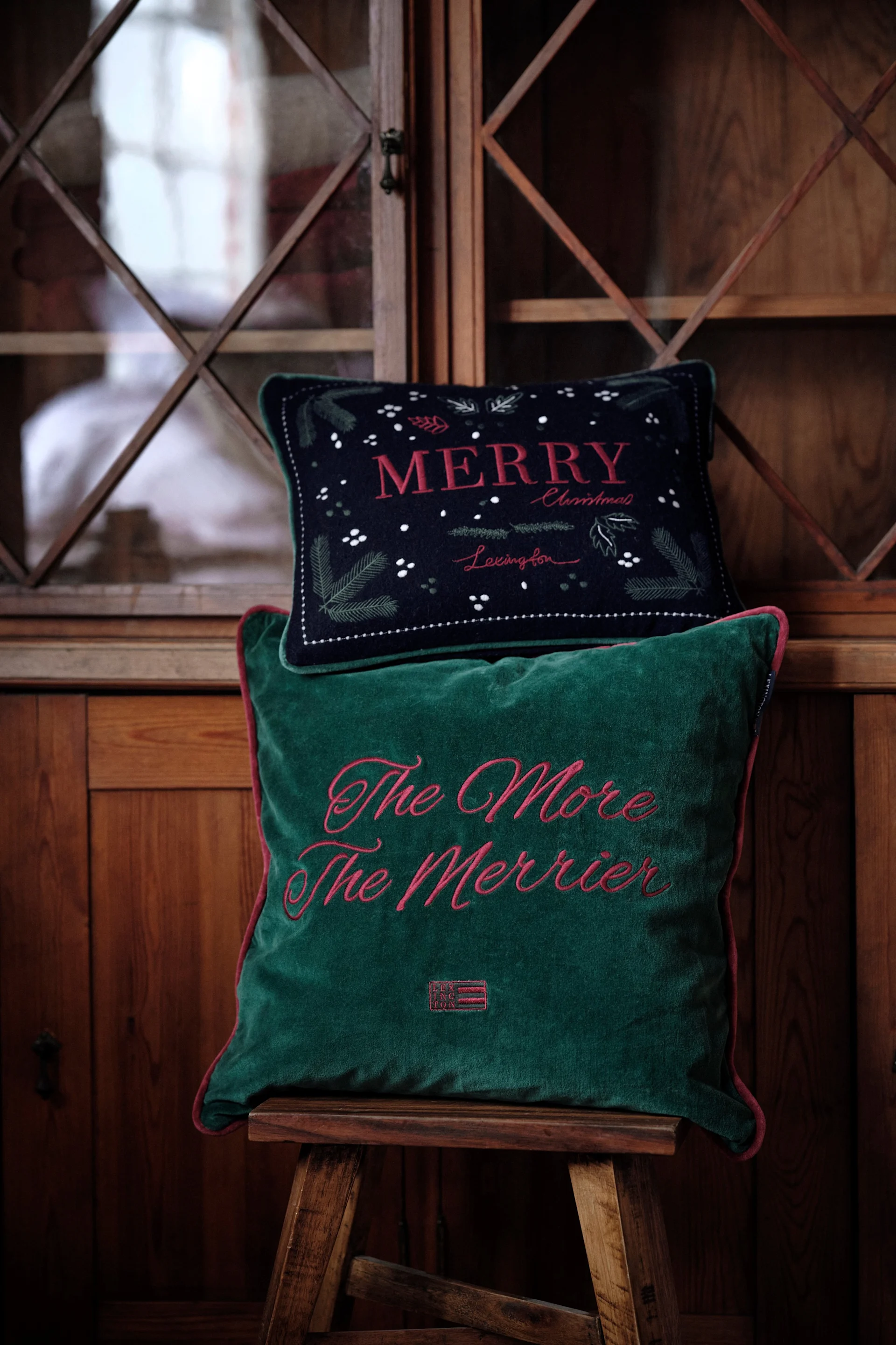 En hånd holder en glaskugle op i et træ. Glaspynt er så populært som nogensinde i julen 2024. 