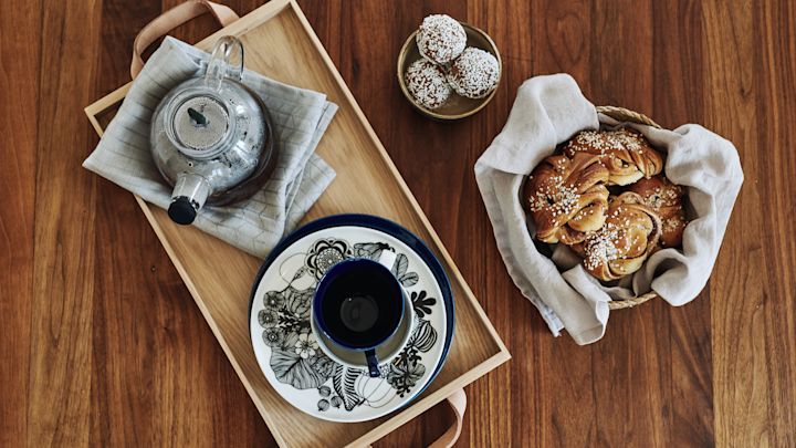 Bordet er dækket op til fika, der er kaffe, kanelboller og fint service som består blandt andet af Siirtolapuutarha tallerkner fra Marimekko.