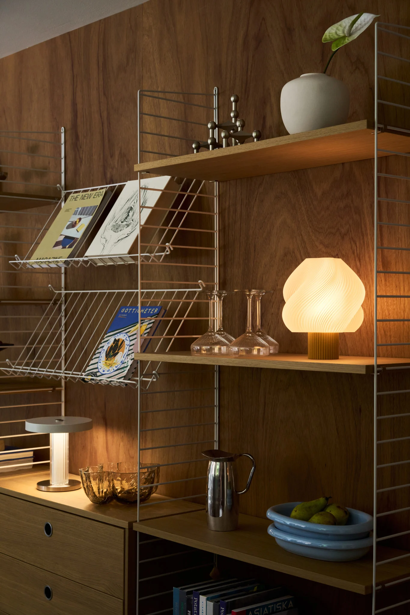Overvej at inkludere flere lyskilder når det kommer til at planlægge din belysning. Her kan du se et spisebord med flere forskellige bordlamper og en dramatisk loftlampe.