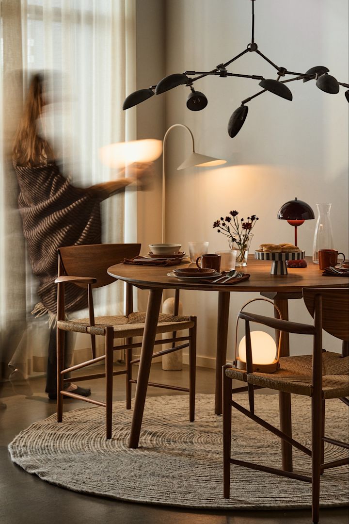 Overvej at inkludere flere lyskilder når det kommer til at planlægge din belysning. Her kan du se et spisebord med flere forskellige bordlamper og en dramatisk loftlampe.