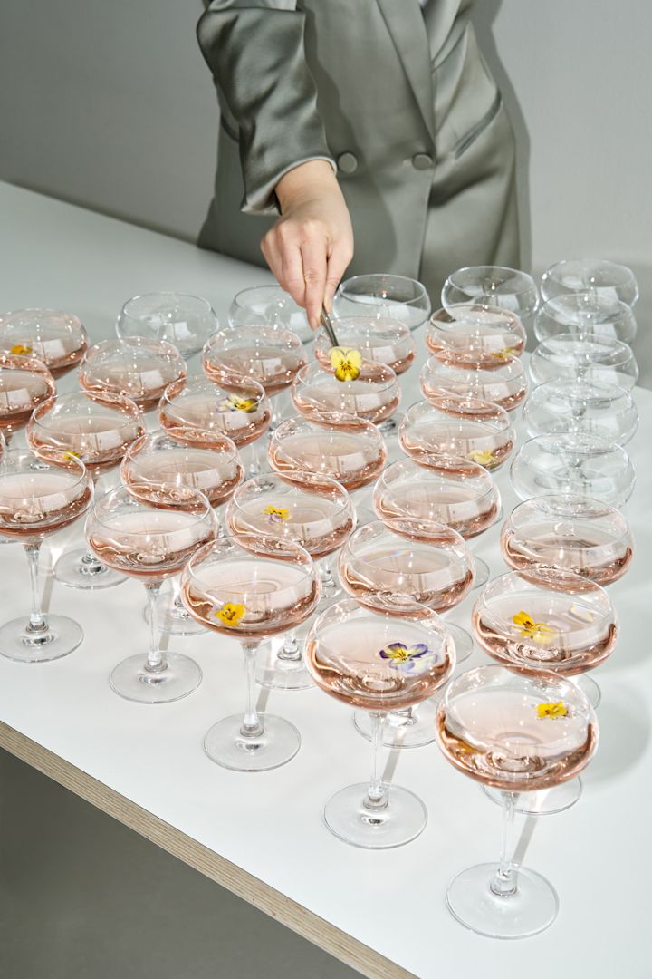 Lær hvordan man holder en fest alle vil huske. Her kan du se et bord fuld af velkomstdrinks i More coupe fra Orrefors.