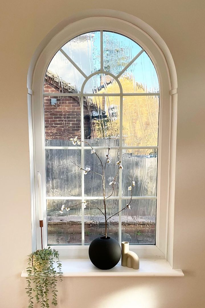 Her ses det smukke buede vindue med vindueskarm af @abrysonhouse, som er dekoreret med lysestager og den sorte kuglevase fra Cooee Design med forårsblomster.