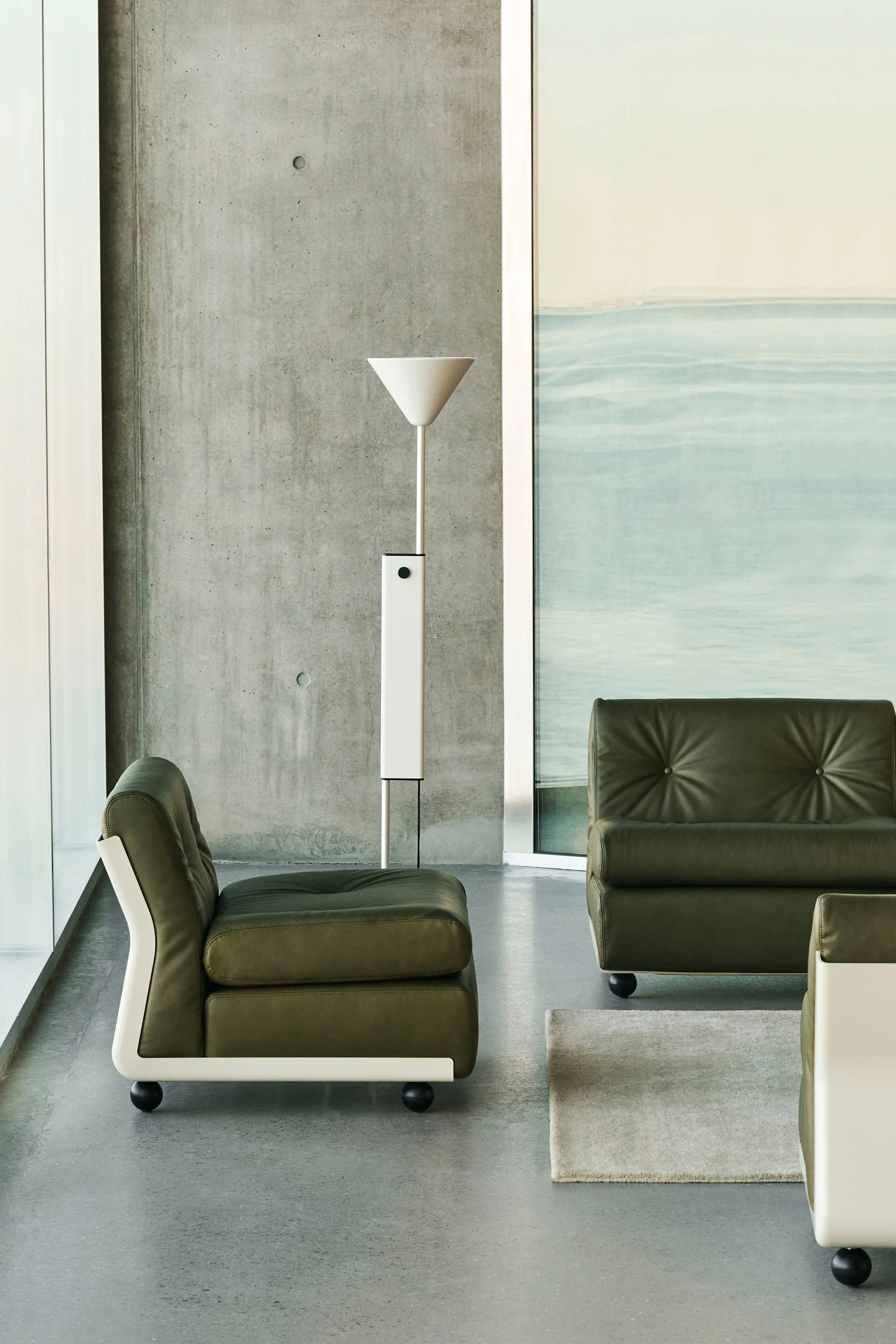 Interiør farvetrenderne i 2025 inkluderer en naturlig nuance af olivengrøn, her kan du se lampen fra Fritx Hansen stående på et sidebord.