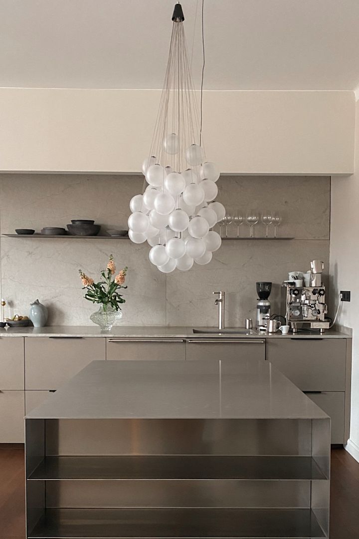 Frisk dit hjem op med trendy lampevalg. Her kan du se Stochastic loftlampen fra Luce Plan, en samling af glaskugler der hænger samlet over en rustfristålbænk.