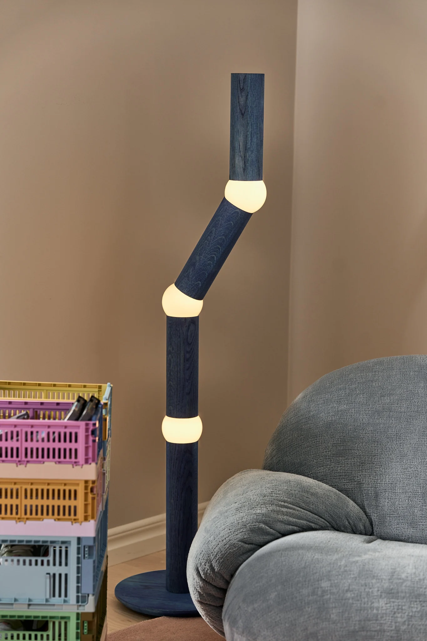 Moderne belysning til alle områder af hjemmet. Her ser du en blå Oblure-gulvlampe med et usædvanligt design i en farverig stue. 