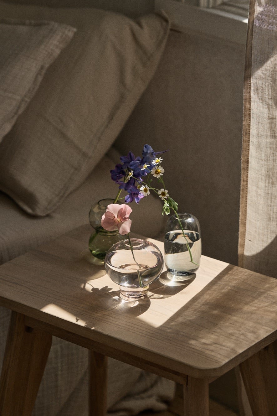 Flere små vaser til individuelle blomster eller små buketter står i en vindueskarm.