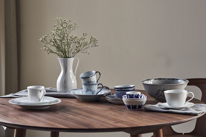 Rörstrands porcelæn klassikere står på et rundt bord: Mon Amie, Swedish Grace, Ostindia i blå og sort og Pli Blanc kanden.