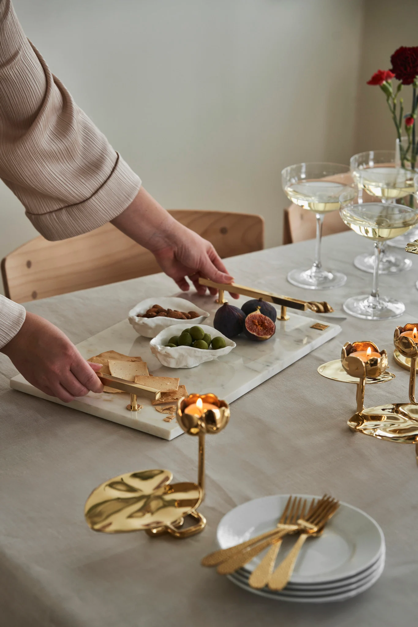 Byd dine venner ind til eftermiddagskaffe på Galentine's Day. Her ser du en marmor bakke fra Hilke Collection sammen med nogle lysestager i guld i form af en åkande.