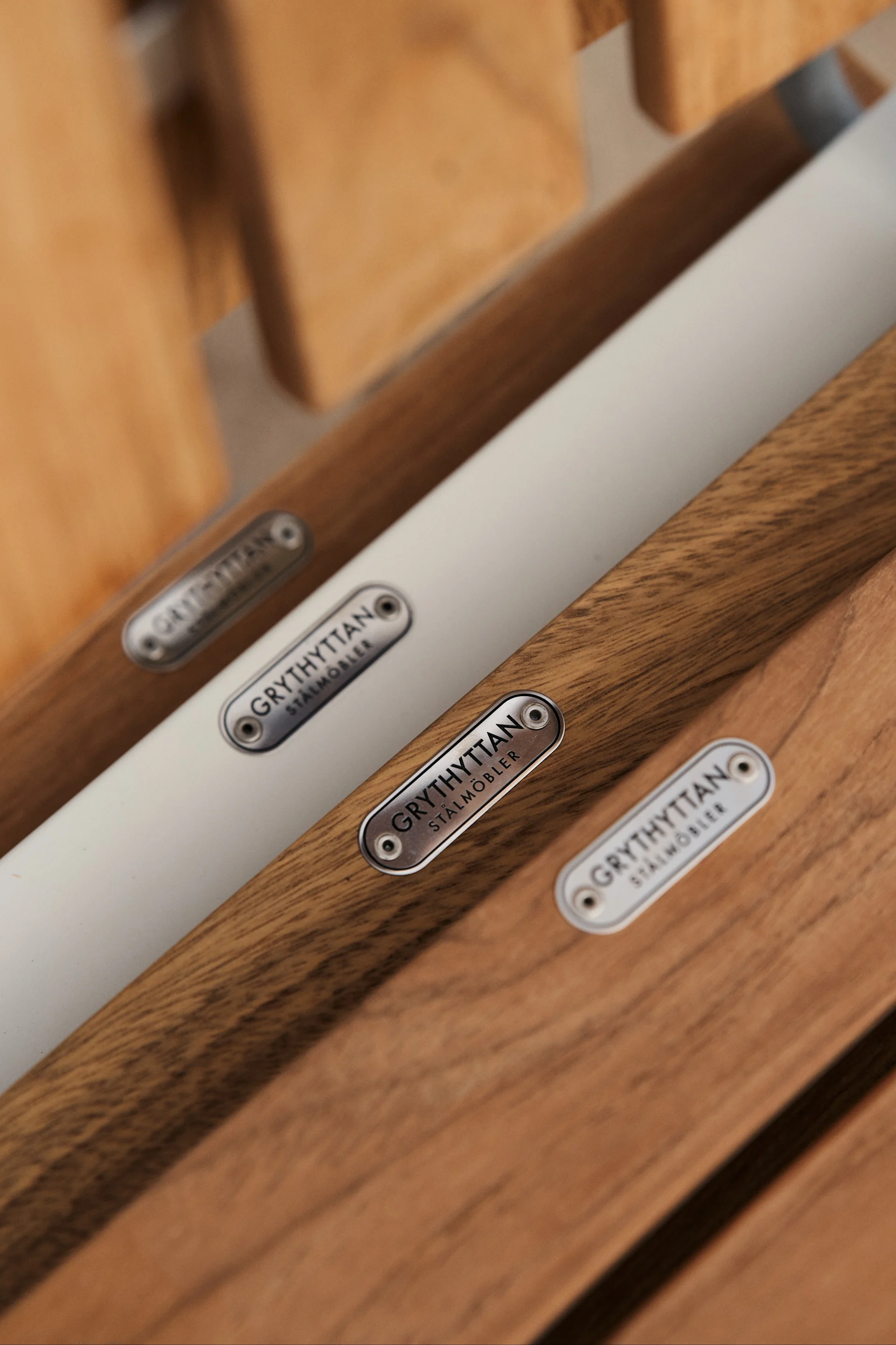 A2-stolen fra Grythyttan Stålmöbler er et ikon blandt udendørsmøbler i teak, her er et billede af detaljerne på sædet hvor logoet er i galvaniseret stål som en fin detalje. 