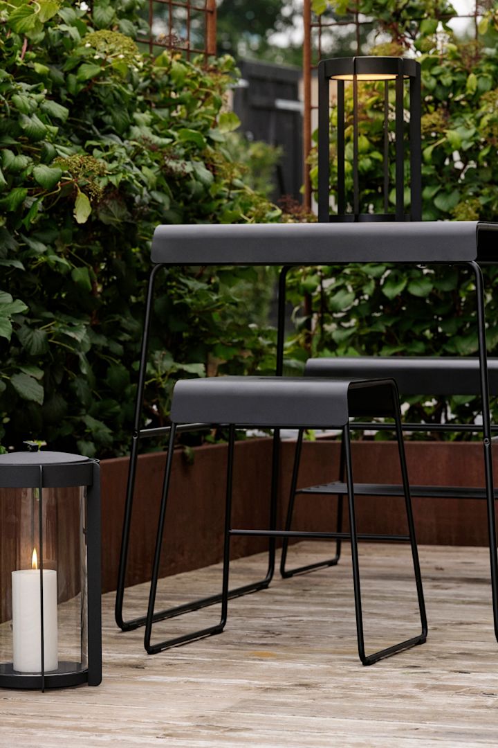 Bordet og skamlen fra Zone Denmarks udendørskollektion kan placeres ude på en terrasse.