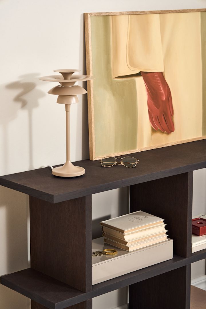 Lager dit lys i spisestuen. Her kan du se bordlampen Picasso i beige fra Belid stå på et sidebord.