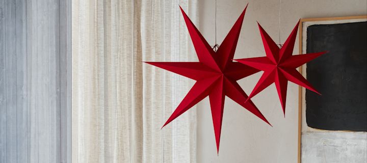 Her ses en nykommer blandt julestjernerne, de rød- og hvidmønstrede stjerner fra Bare-kollektionen fra Scandi Living, som hænger på en dør.