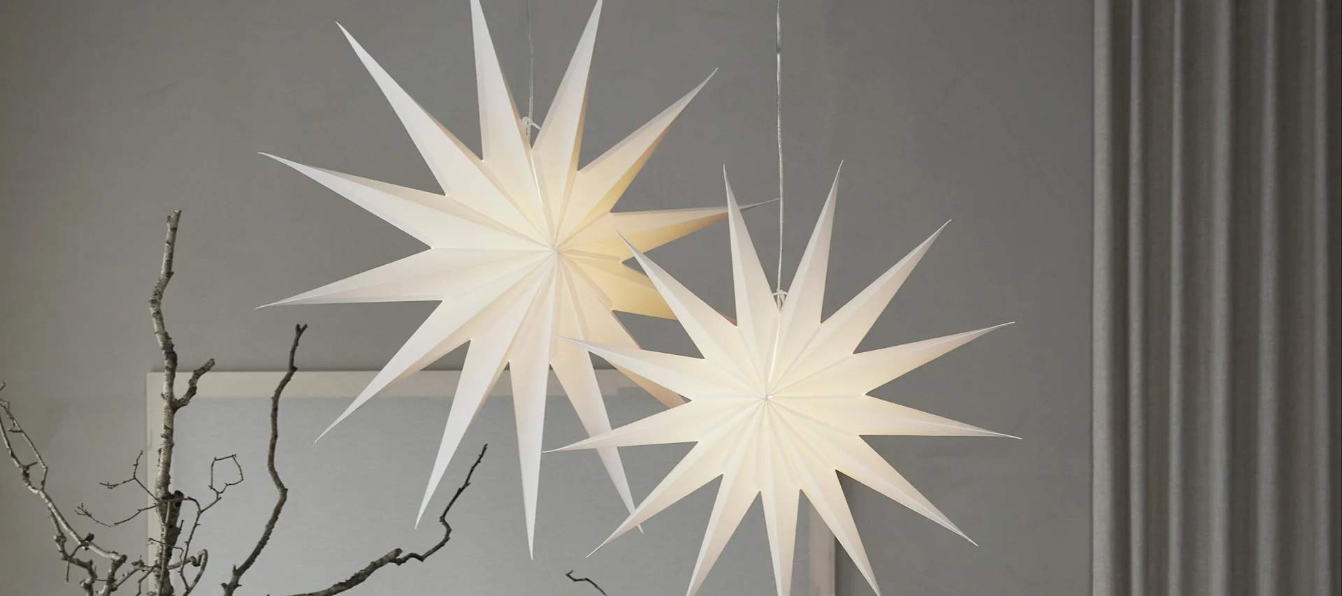 Her ses en nykommer blandt julestjernerne, de rød- og hvidmønstrede stjerner fra Bare-kollektionen fra Scandi Living, som hænger på en dør.