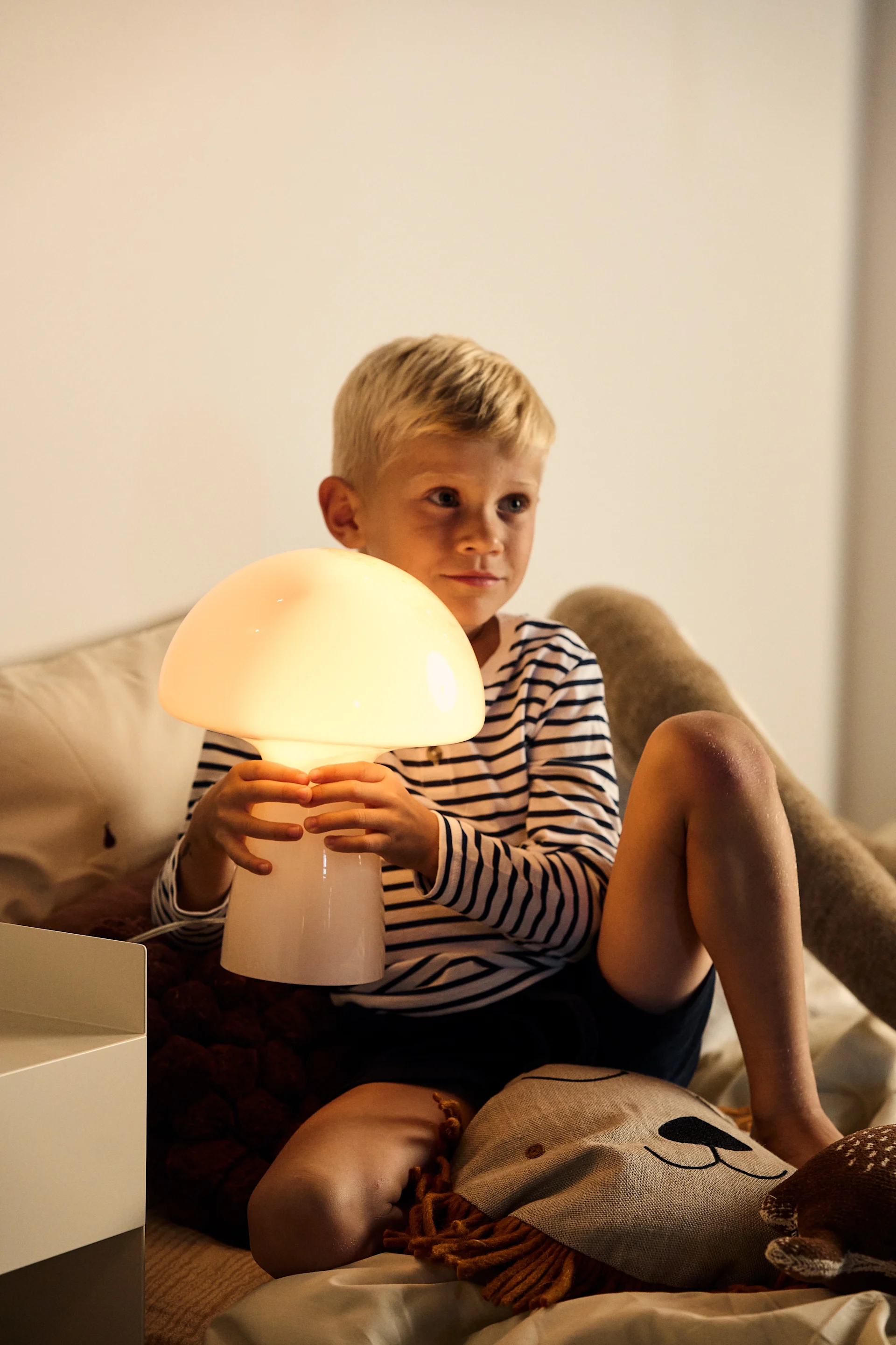 Indret børneværelset med belysning da det er vigtigt at møde de behov der findes, om det er lys til leg eller til at læse. Her er Fungo bordlampe i beige fra Globel Lighting, en bærbar lampe med form som en svamp.