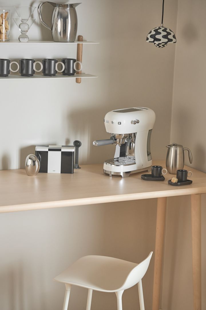 Smeg-kaffemaskinen, som her er vist i et hjørne, er særligt velegnet til en hjemmekaffebar med en Flowerpot-pendel fra &tradition som belysning.