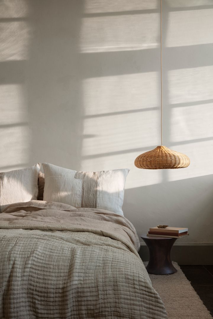 Et hyggeligt soveværelse med bløde puder og et fint sengetæppe fra Ferm Living.