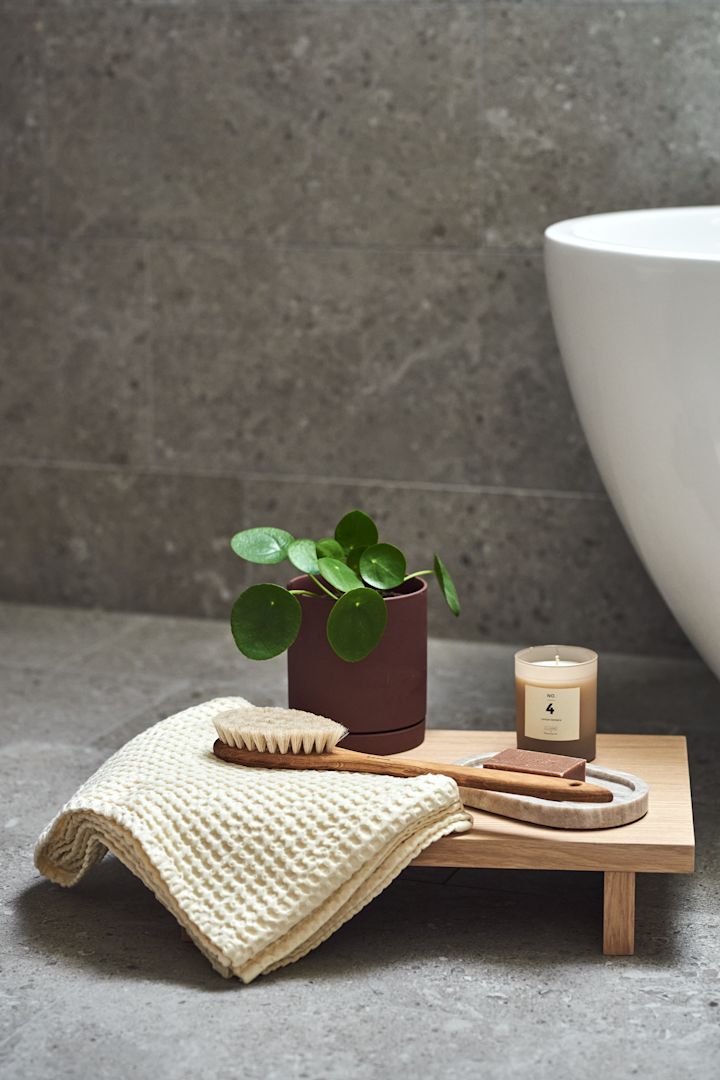 Skab et hjemmespa på badeværelset - bløde håndklæder fra Ferm Living, en træbørste til kroppen fra Iris Hantverk og et duftlys fra Bloomingville.