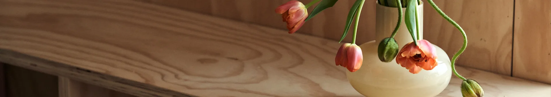 Indretningstips og de nyeste indretningstrends at læse om hos Nordic Nest. Her en gul vase fra Marimekko med orange tulipaner i. 