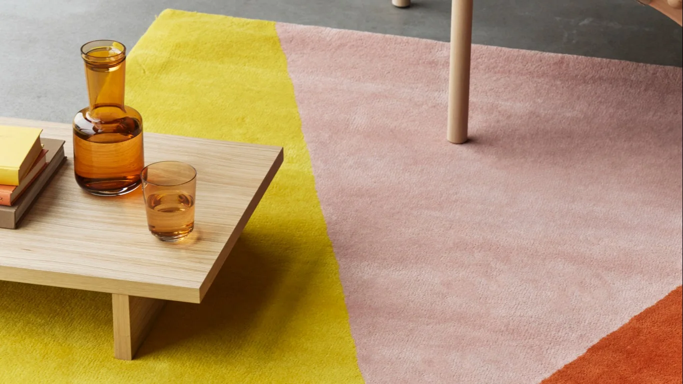 En stue med et beige tæppe og grøn uldplaid fra NJRD Edges kollektion.