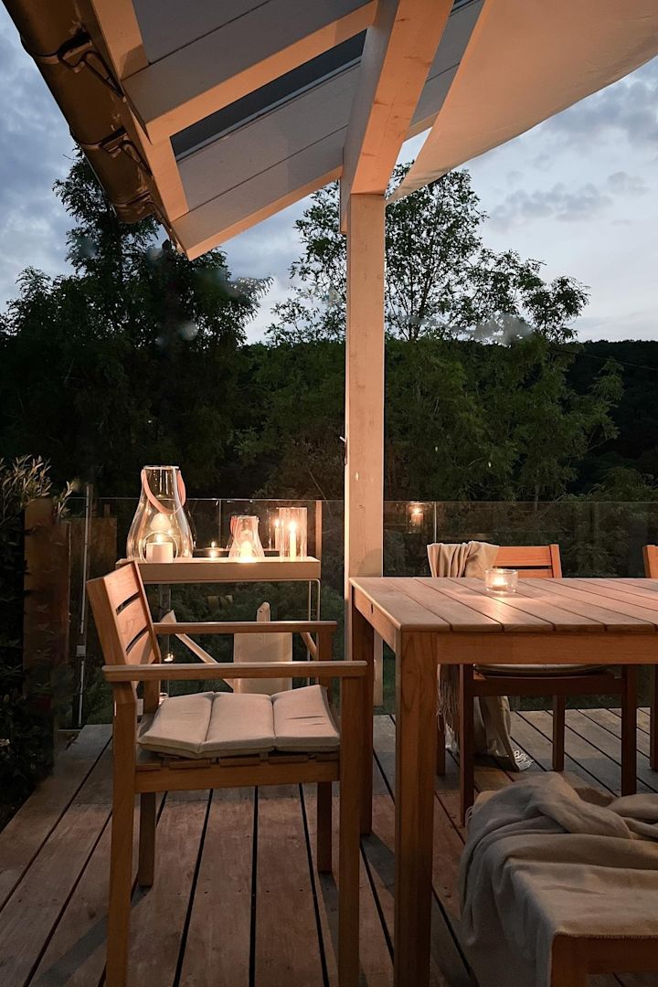 Placer flere lanterner og vindlys på din terrasse for at skabe en hyggelig atmosfære. Her kan du se Design with Light-lanternen fra Holmegaard på træbordet på terrassen fra den tyske influencer @zuhauselig.