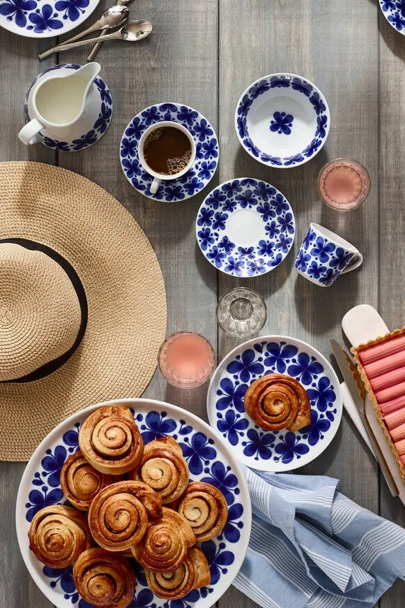 Svenske kanelsnegle er det mest berømte fika-bagværk, selv uden for Sveriges grænser. Her kan du se dem serveret på Rörstrands Mon Ami-stel på et udendørs bord med en sommerhat.