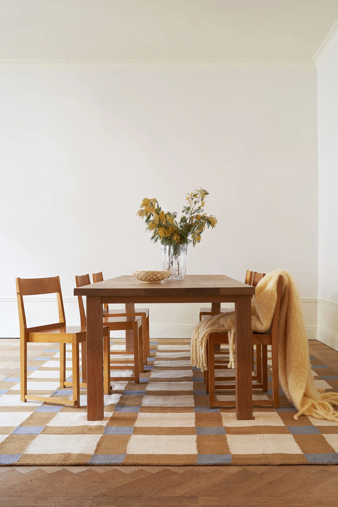 Kirsebærrød er en af indretningsfarverne for 2025, her kan du se Matin lampen på en rød stol mod en baggrund i samme nuance.