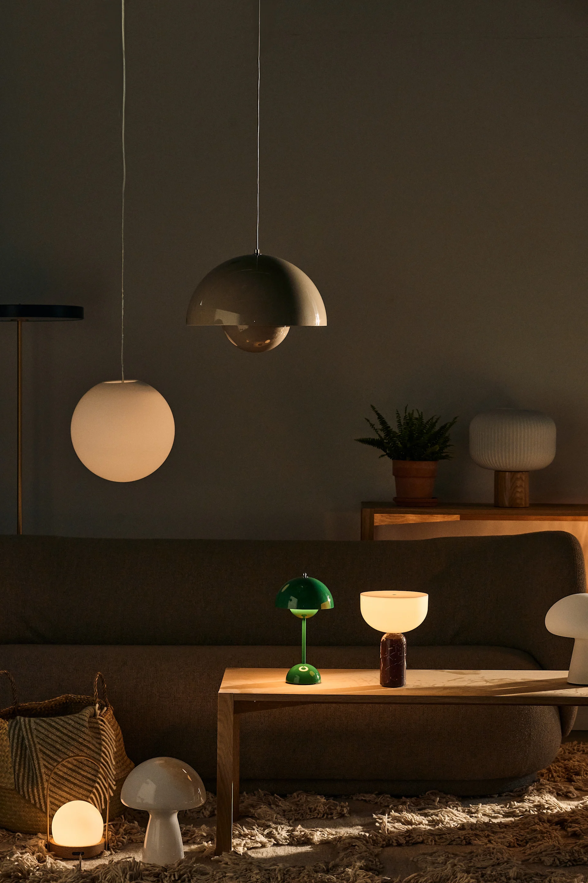 Billede der viser flere forskellige lamper i stuen, inklusiv Luna loftlampen, en hvid globe lampe fra Design House Stockholm, og Flowerpot loftlampen fra &Tradition.