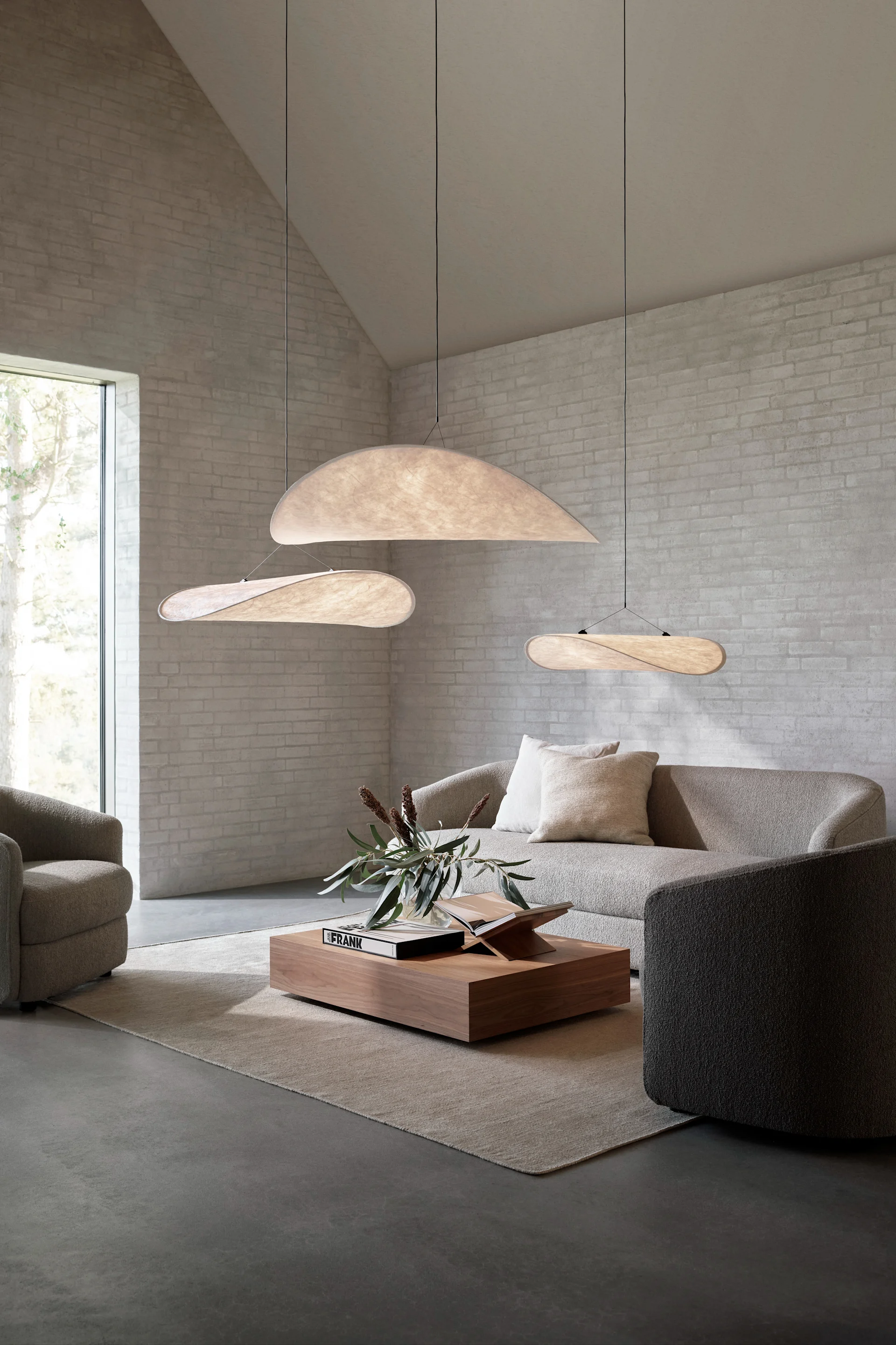 En stor stue med tre Tense pendler der hænger over en sofa i en gruppe.