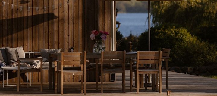 Et hyggeligt spiseområde på en terrasse i træ.