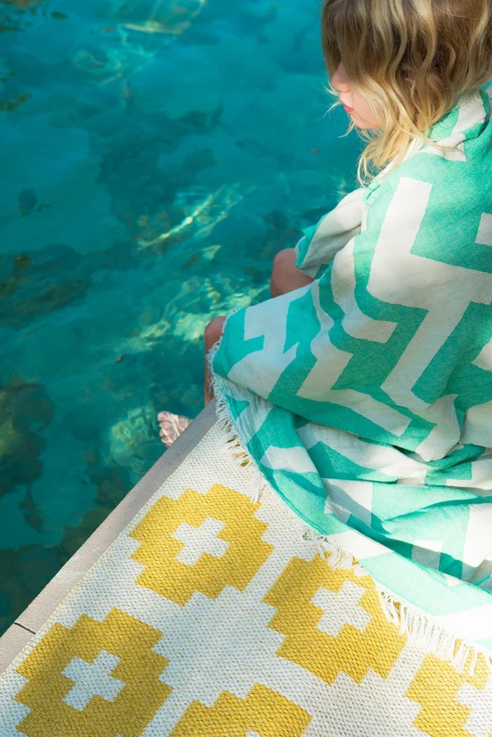 Udendørs tæppe: Flower-tæppet fra Brita Sweden har ikke noget imod at blive vådt, så du kan placere det ved siden af poolen uden problemer.