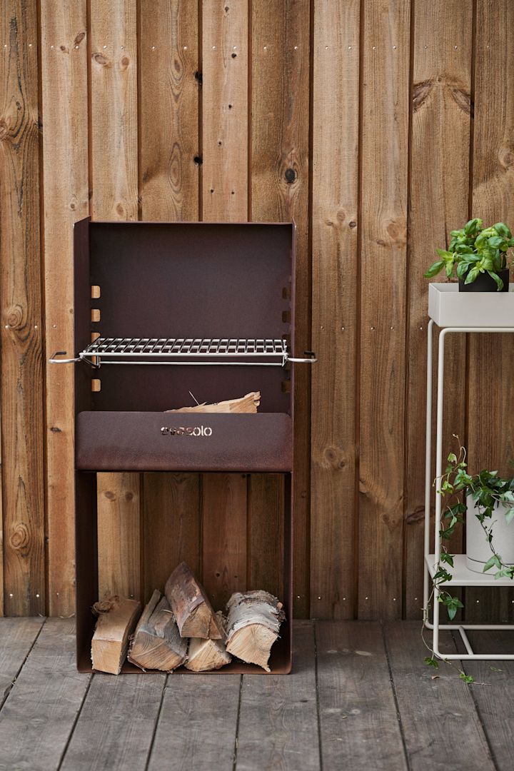 Den rustikke FireSpot-grill fra Eva Solo står på en træterrasse.