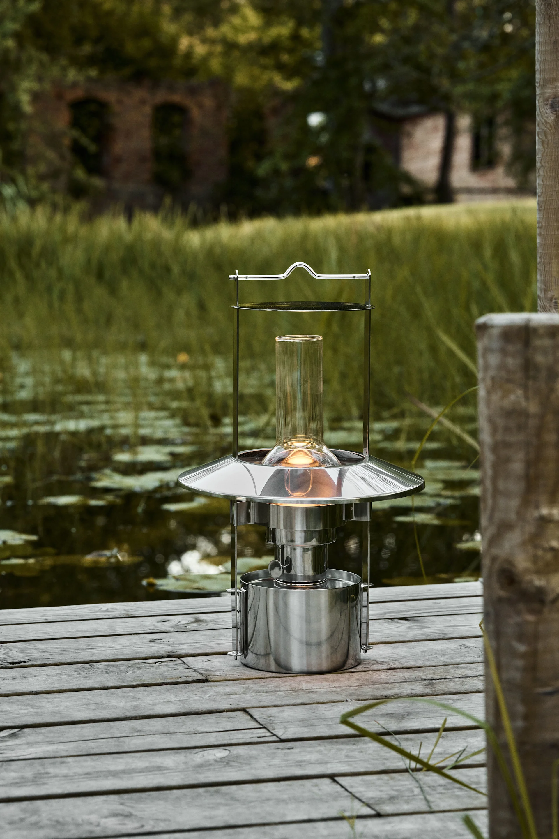 Lanterner og lygter til udendørs brug - her ses den 43 cm store Stelton skibslampe, som er lavet af rustfrit stål og kører på lampeolie.