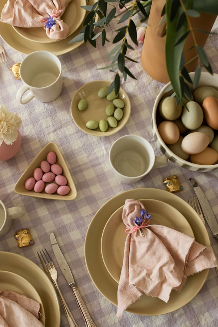 Gode ideer til påskens borddækning omfatter altid en smuk servietfoldning, som du ser her med en enkel krølle og blomst viklet om en Scandi Living-hørserviet i pink. 