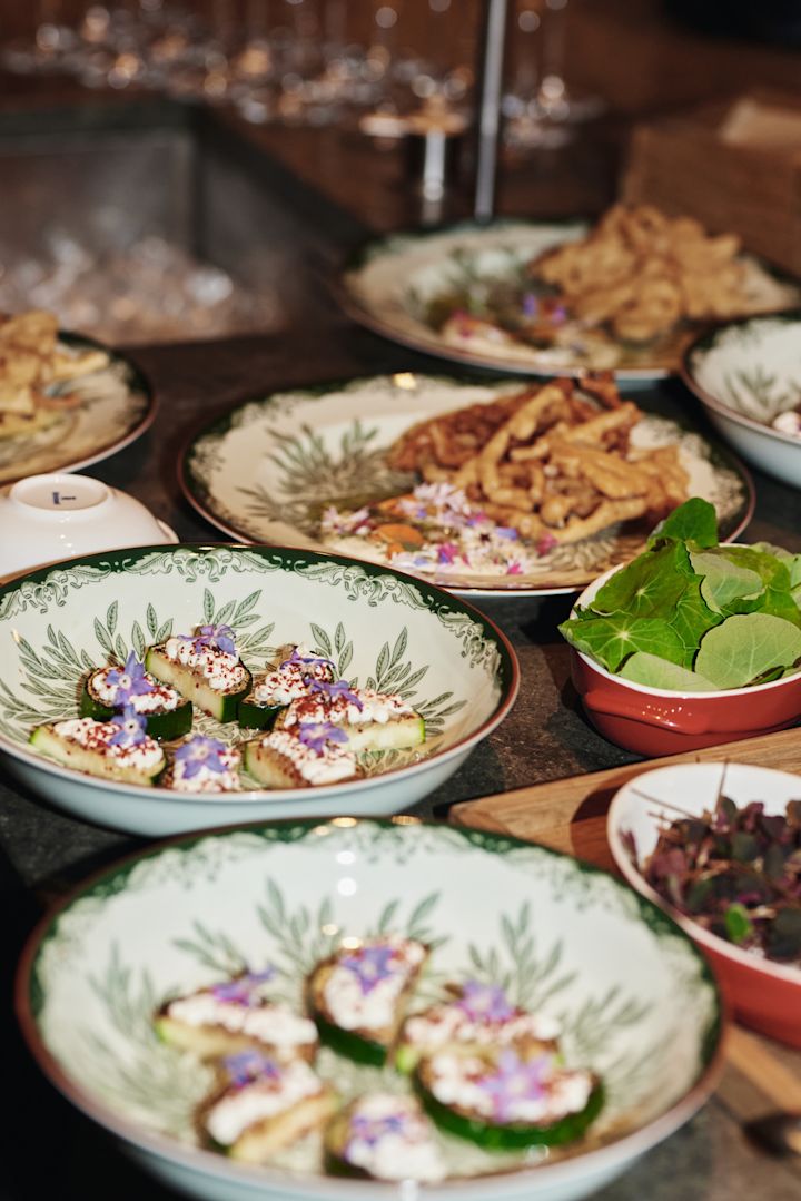 Her kan du se en dyb Ostindia Floris tallerken med en professionel anretning af mad. En del af en grøn borddækningside for en restaurant fornemmelse som kan skabes der hjemme.