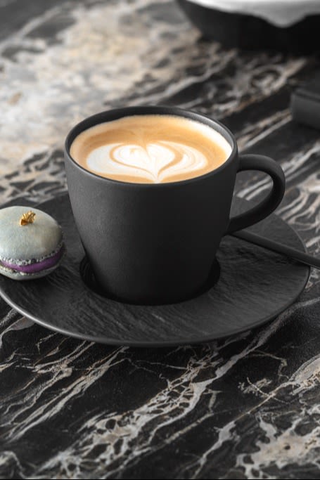 En kop kaffe med mælkeskum latte art på toppen.