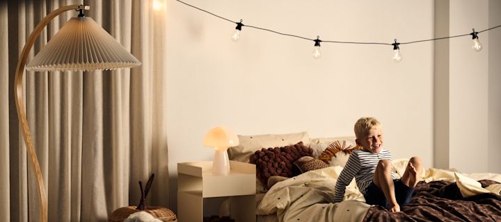 Planlæg belysningen i dit hjem med vores bedste tips, her ser du et børneværelse med flere lyskilder som en lyskæde, en bordlampe og en gulvlampe.