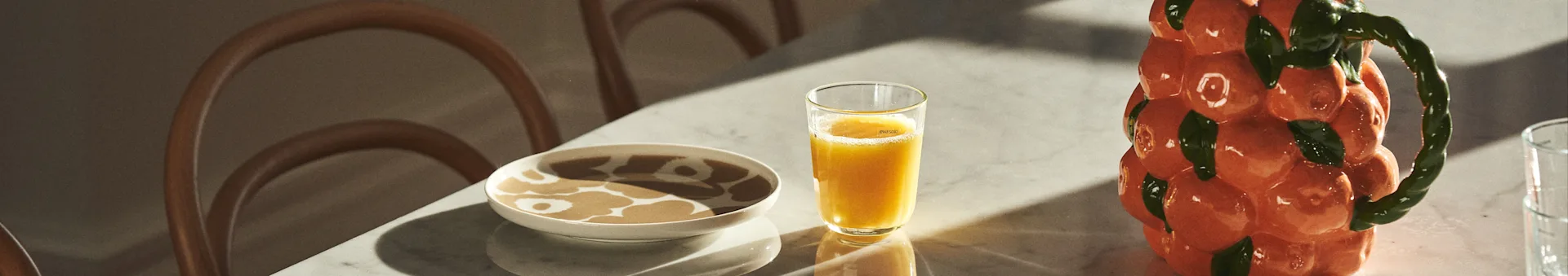 Bordstel med Marimekko-porcelæn, juice og karaffel fra BYON i design af mandariner. 