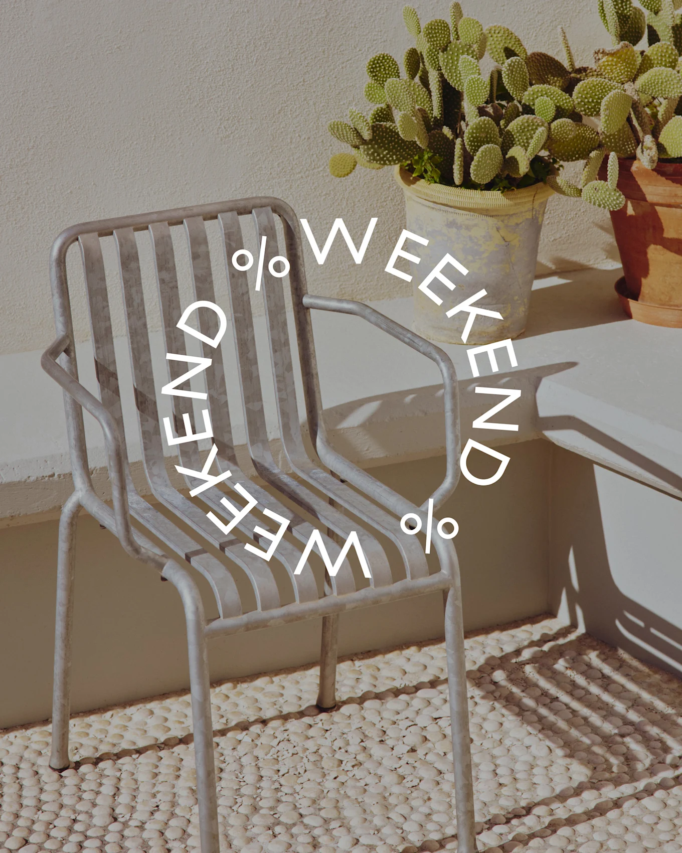 Grå stol med metalribber ved en kaktusplante i potte, med cirkulær tekst 'WEEKEND % WEEKEND %'.