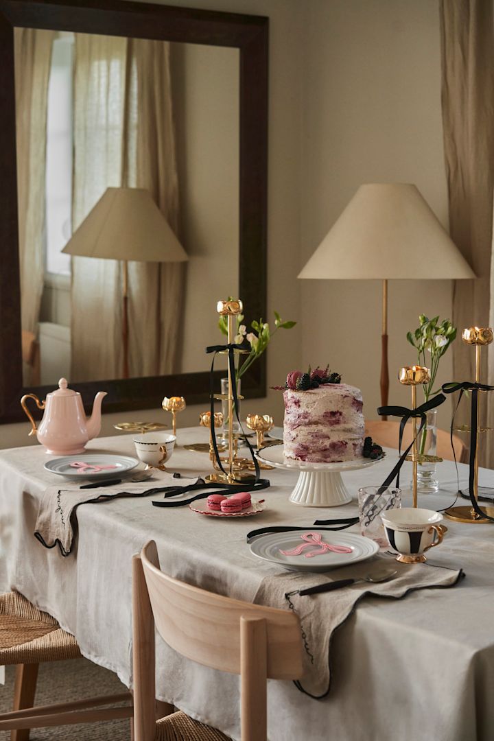 Fejr Galentine's Day med en te indbydning med dine favorit veninder. Her ses et bord dækket i lyserød og guld med sorte detaljer fra Hilke Collection.