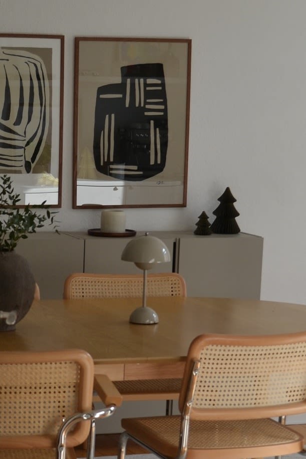 Greige er på vej tilbage i farvetrendsene for 2025, her kan du se den trådløse Flowerpot VP9 fra &Tradition på et spisebord i træ.