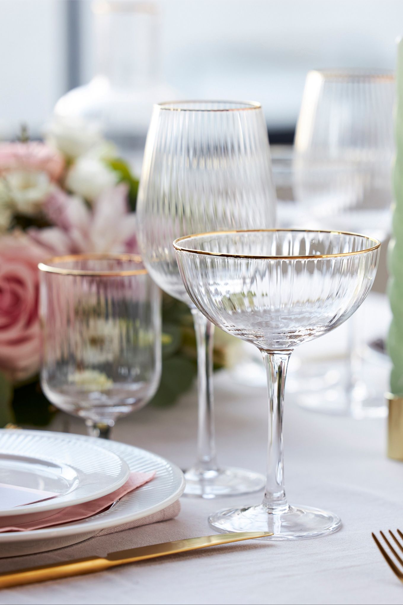 Glassene fra Palermo-kollektionen fra Lyngby Glas har en elegant gylden kant og er her vist på et stilfuldt dækket bord i hvid, rosa og guld.