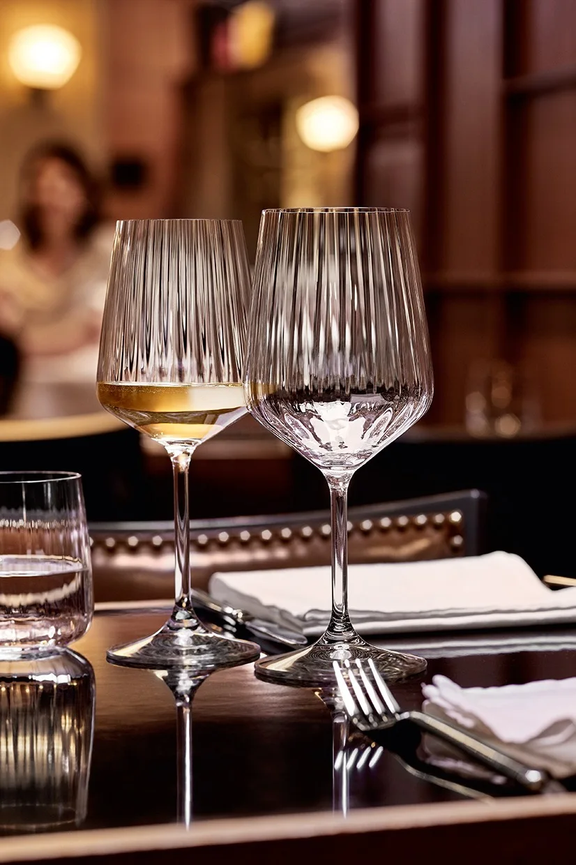 De stilfulde LifeStyle-glas fra Spiegelau, som her står på et dækket bord, skaber en stilfuld borddækning og indbyder til at nyde særlige øjeblikke.