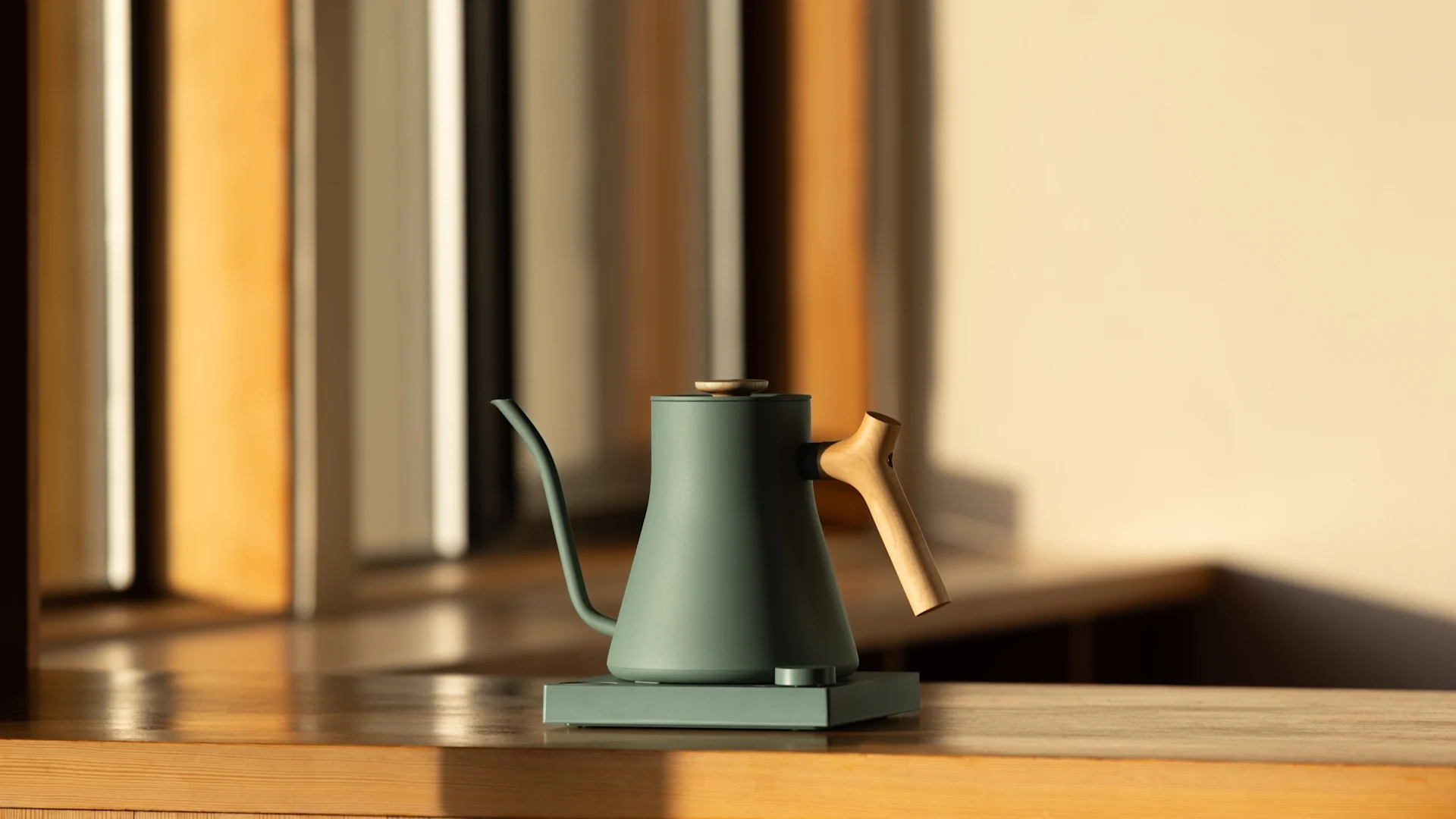 Den flotte og elegante Stagg EKG elkedel fra Fellow står på et tråbord i et flot oplyst rum.