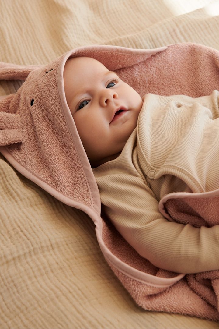 Badehåndklæder med hætte som Sand Terry-hættehåndklædet fra Garbo&Friends holder babyen varm, selv efter badet, hvor der er særlig risiko for at fryse. Derfor er badehåndklæder som dette en god gave til babyshower.