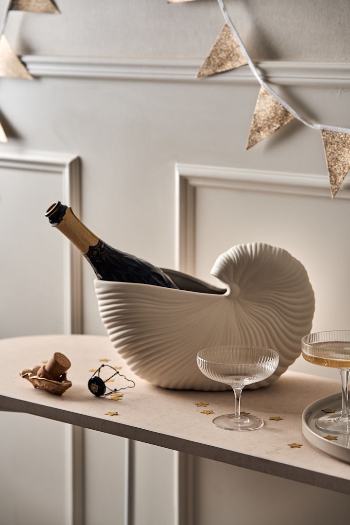 Udforsk hvordan man holder en fest med en drink station, her kan du se Georg Jensens champagnekøler med Orrefors More champagne coupeer arrangeret på et bord som en drinkstation med selvbetjening.