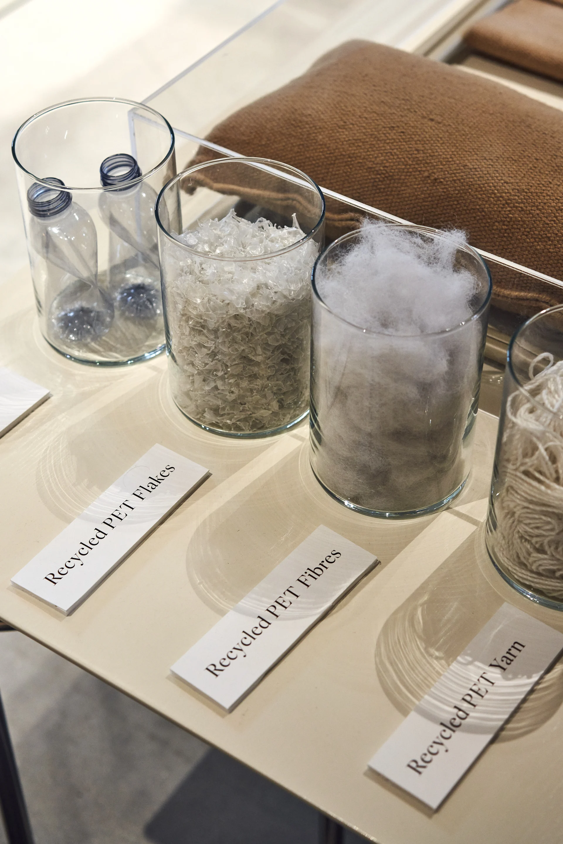 Glas beholdere fyldt med forskellige genanvendte materialer i Ferm Livings showroom.