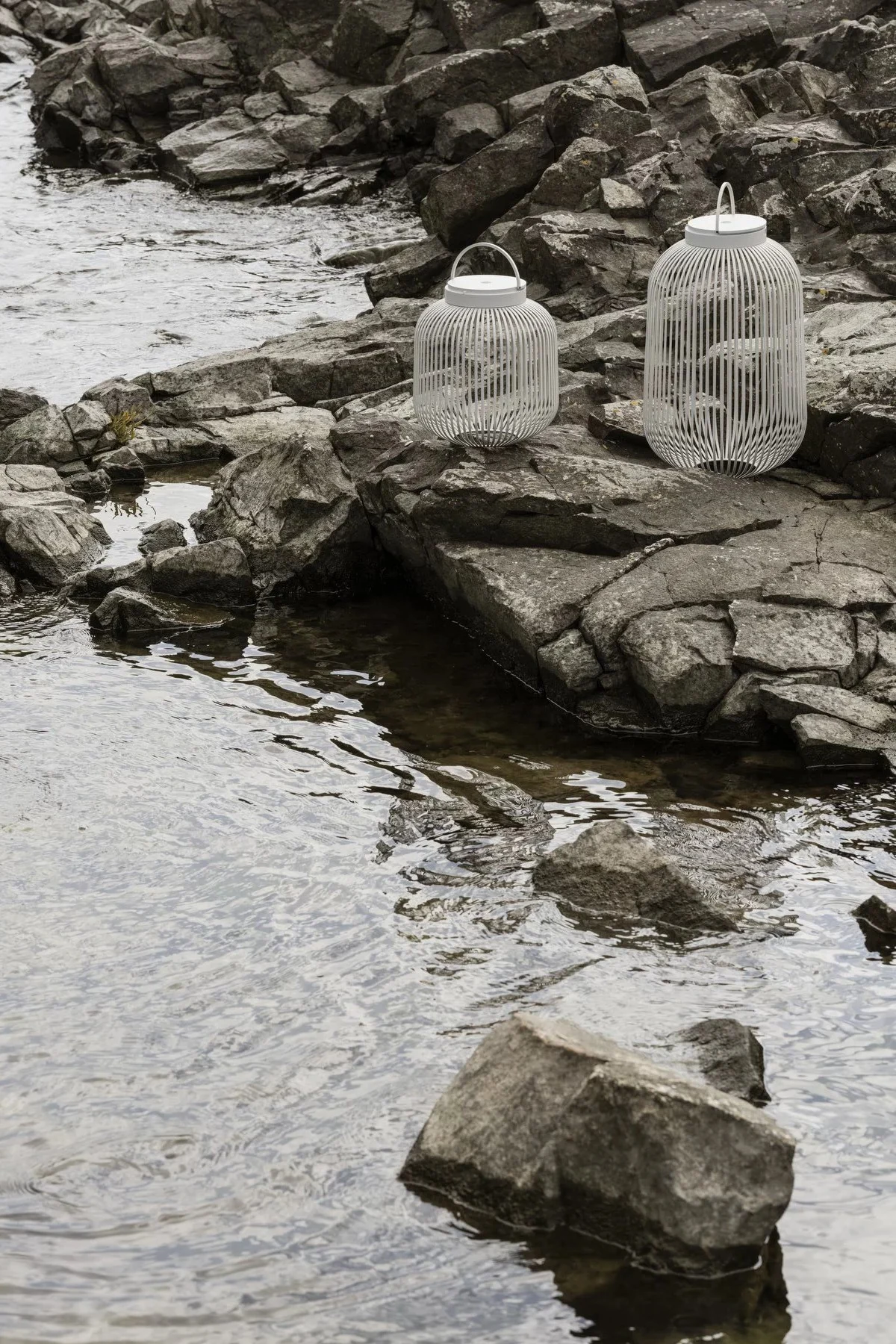 Lanterner og lygter til udendørs brug - her ses Lito-lygten fra Blomus i Nomad i forskellige størrelser stående i en gang.