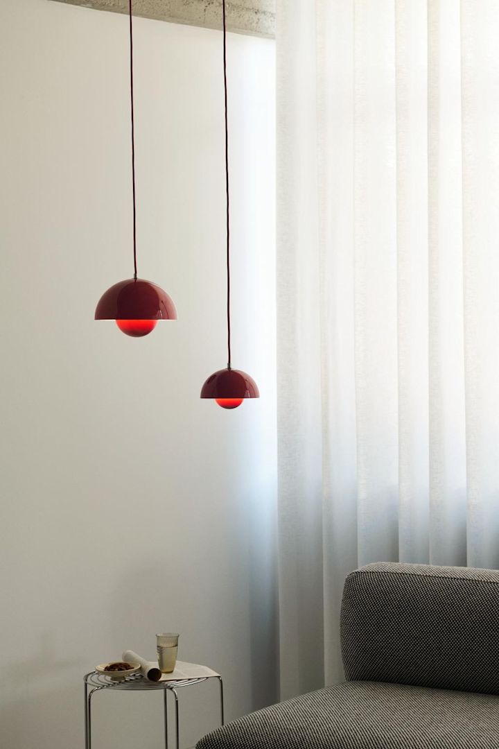 Opdater dit hjem med disse ideer til moderne loftslamper. Her ser du Flowerpot-lampen fra &Tradition i to forskellige størrelser, der hænger i en stue over en sofa. 
