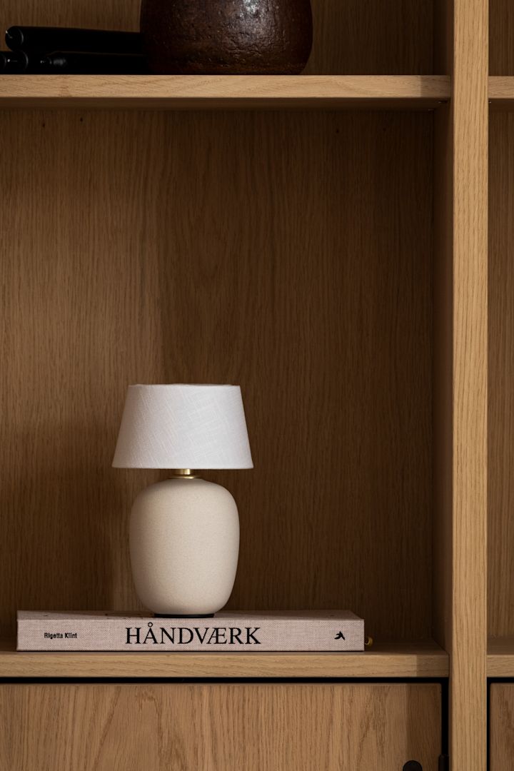 Sæsonens mest trendy svampelampe - den portable Torso bordlampe fra Menu set her i en træ bogreol.