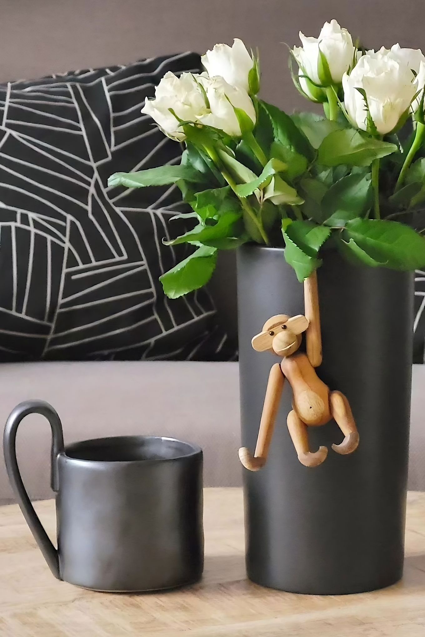 Giv en sød abe fra Kay Bojesen i mors dag-gave, som her hænger i en sort vase med hvide tulipaner ved siden af Flow-kruset fra Ferm Living hjemme hos @despina2024.